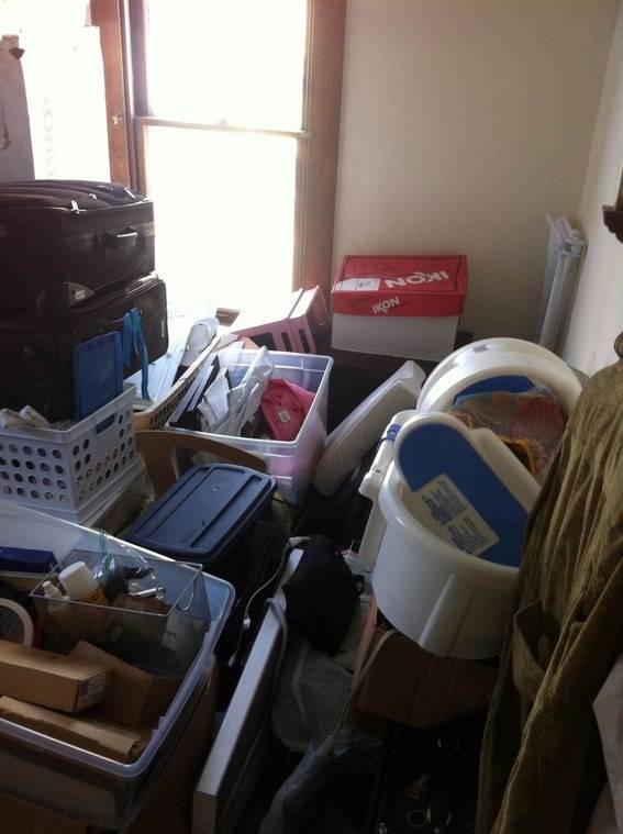 Baskets and bins piled on top of each other in a cluttered room.