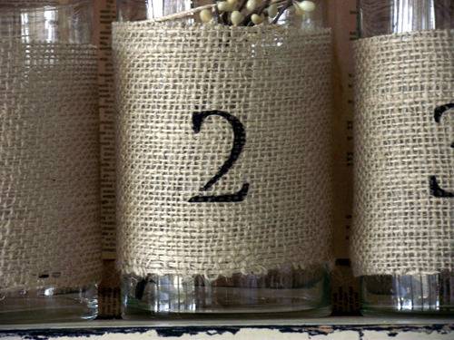Canvas wrapped jars with numerals painted on outside.