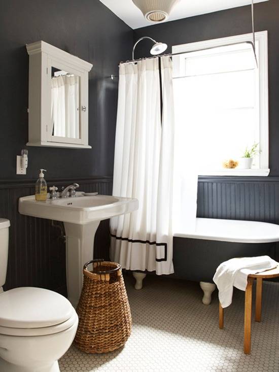 A white toilet, sink and tub are in a black bathroom.
