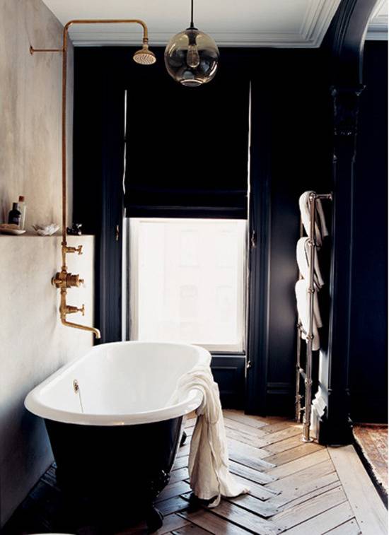 A bathroom with black themed walls and tubs.
