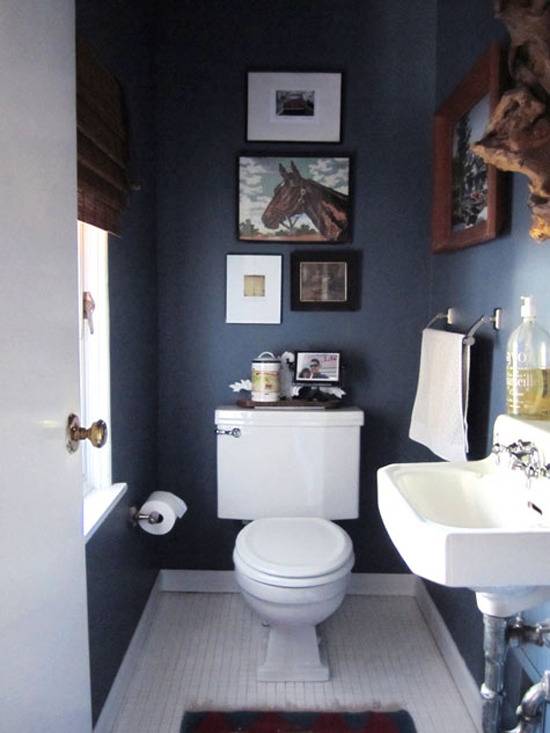 A bathroom with white sink and toilet, with a horse pic above the toilet.