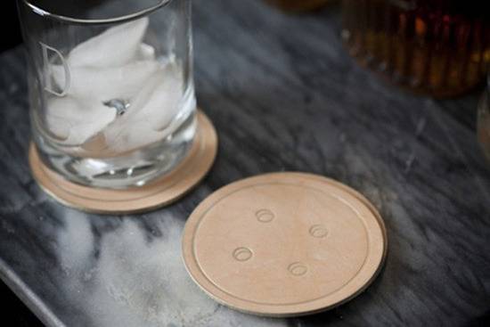 Two button coaster with a glass of ice water on it.