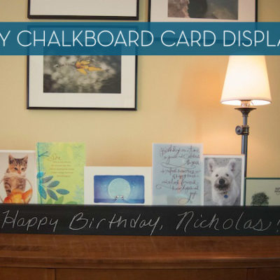 Chalkboard display rack with greeting cards near a lamp in a living room.