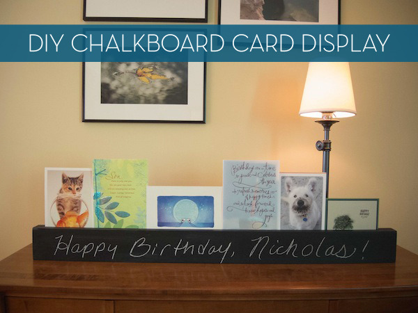 Chalkboard display rack with greeting cards near a lamp in a living room.