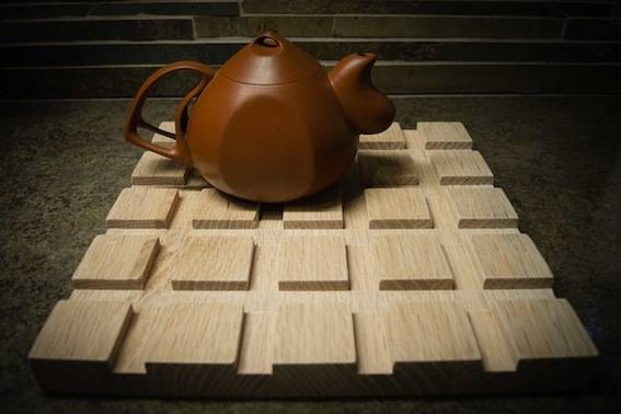 A brown kettle sits on a wooden grid.