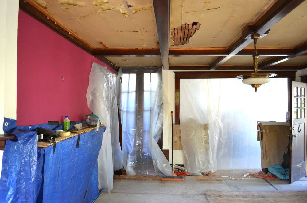 Gut renovation of a room with plastic sheeting on the walls.