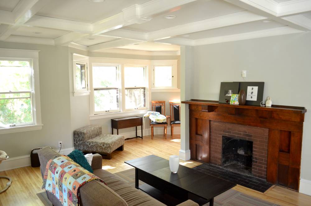 Wood fireplace with a sofa, love seat, and coffee table in a living room.