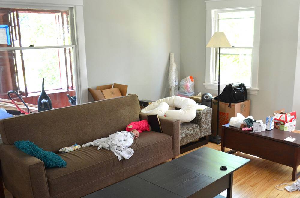 Living room with furniture strewn with clothing.