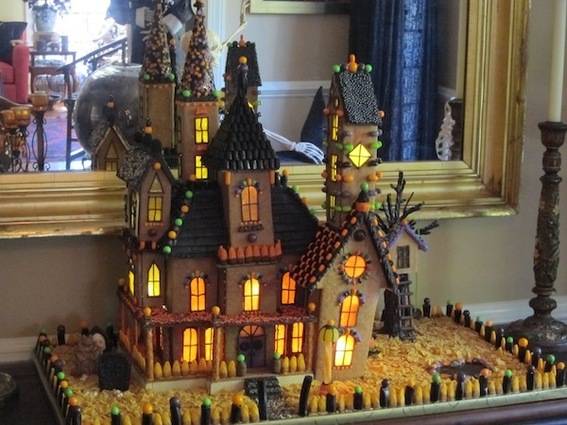 A model of a haunted house sits near a mirror.