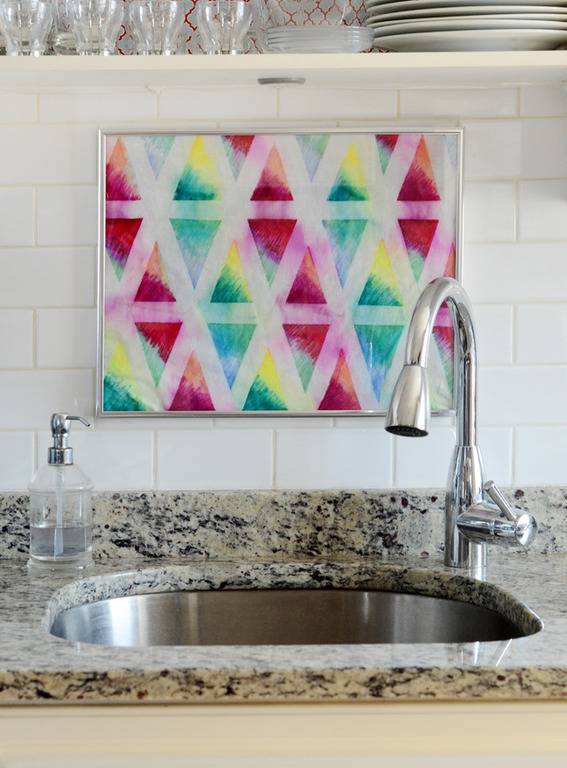 A colorful rag is hanging behind a sink.