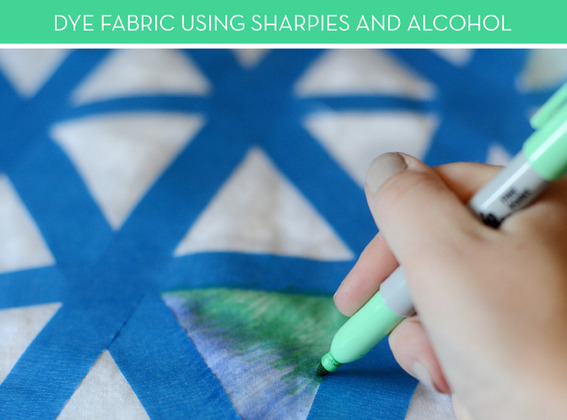 Coloring fabric with a green marker.