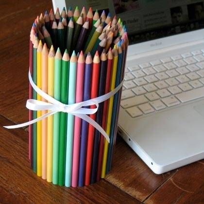 Pencils glued together to form a pencil holder next to a lap top.