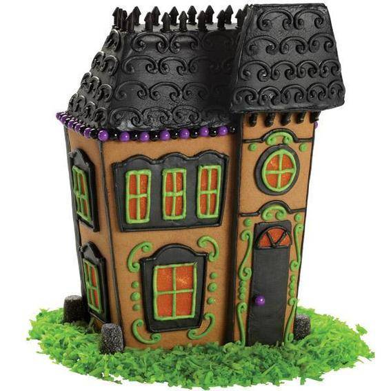 Gingerbread haunted house with black roof and green frosting grass.