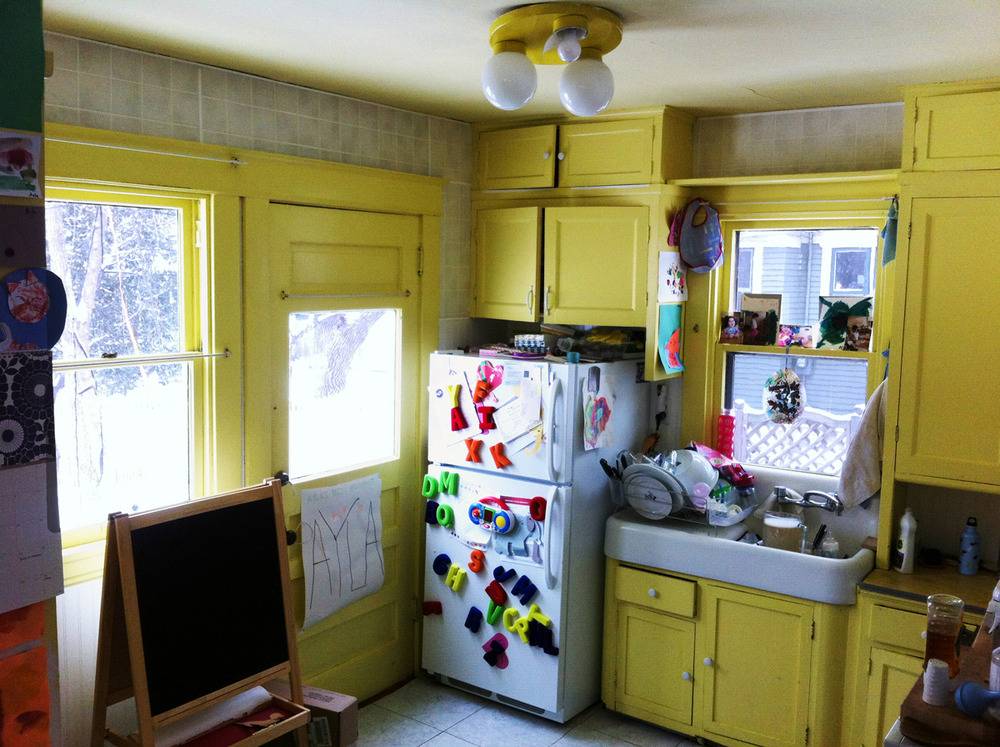 Appliances are visible in a yellow kitchen.