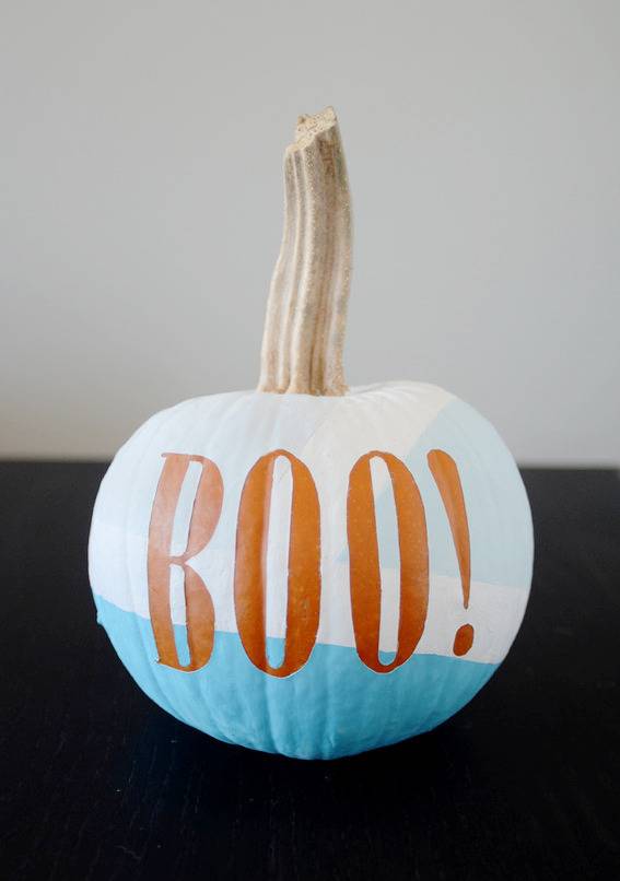 A pumpkin painted white and blue with the word boo on it.