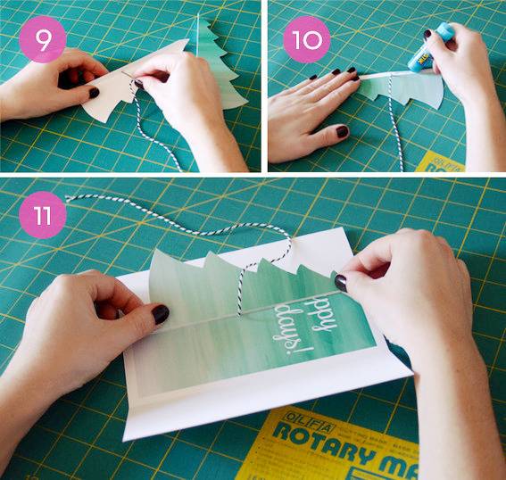 A person folding a card on a green gridded material.