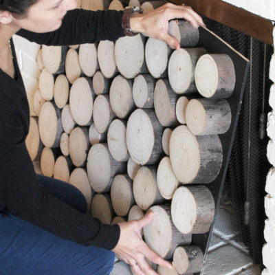 The ends of round fire logs have been cut off and glued in a stack to create the illusion of a stack of firewood.