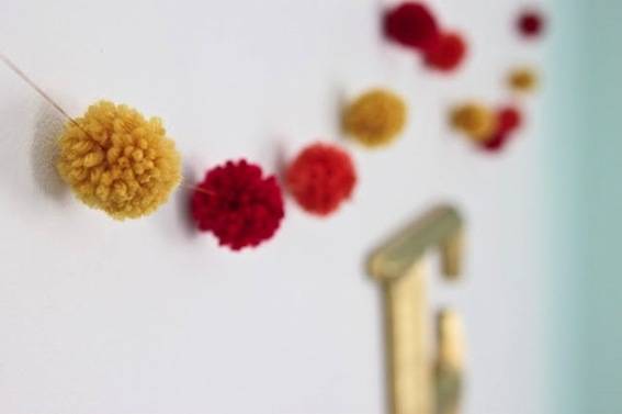 Pom poms strung on a string into a garland.