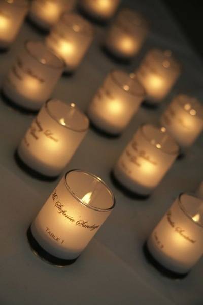 Several tea candles sit on a gray surface together.