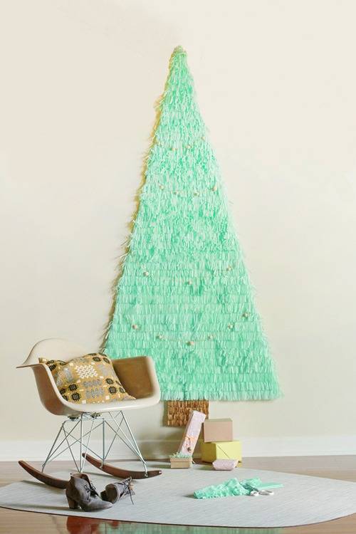 Papier mache Christmas tree on a wall near a chair in a living room.
