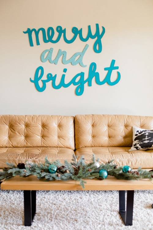 The words "merry and bright" are written in blue behind a tan couch.