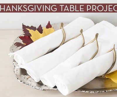Folded towels and colorful maple leaves are on the plate.