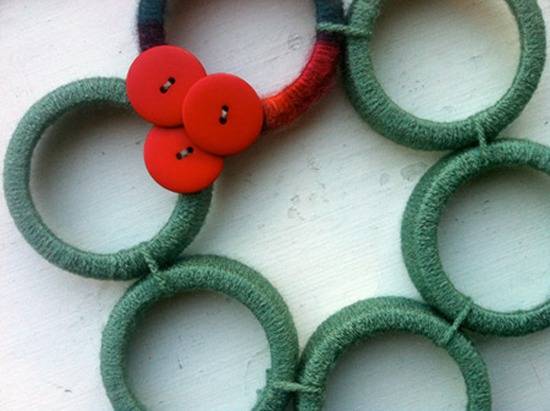 Wreath garland made with tread and decorated with red buttons.