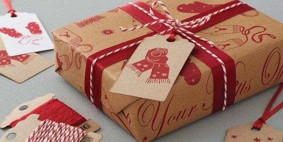 A Christmas present has been wrapped with twine over the ribbon and a large gift tag.