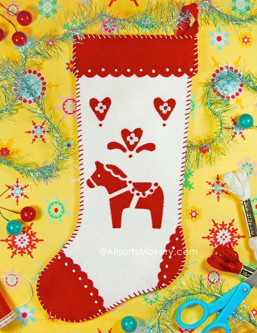 A red and white stocking sits on a yellow background with craft tools.