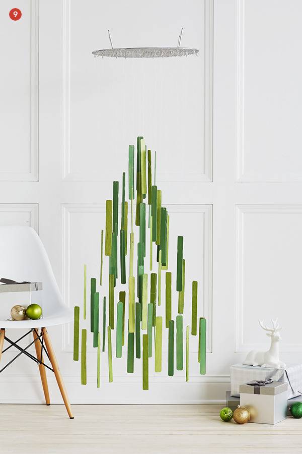A mobile is made of long green vertical strips with the overall shape being a Christmas tree.