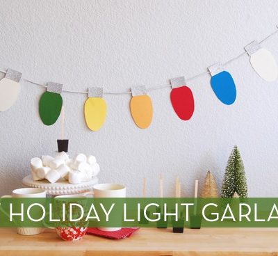 Paper Christmas lights on a string hanging on a wall.