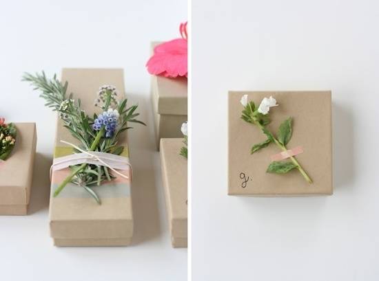 Gift boxes have flowers taped or tied to their tops.