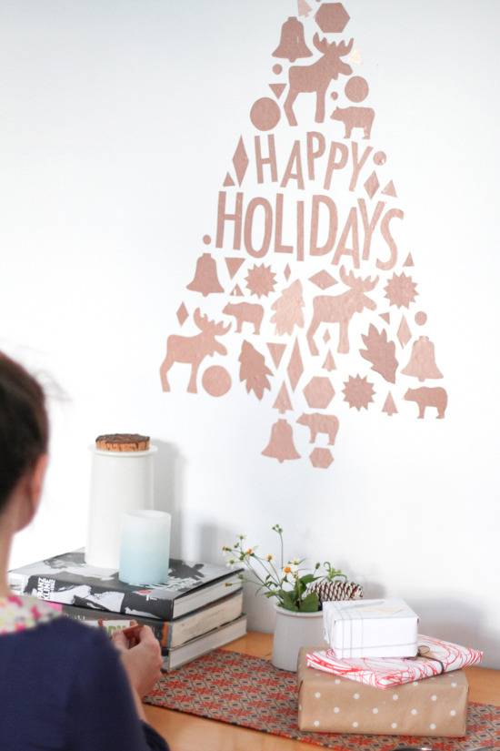 Vinyl Christmas tree with moose, elk, leaves, and bells that says "Happy Holidays".