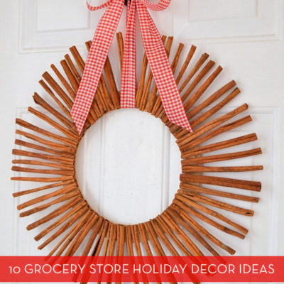 A wreath made from cinnamon sticks hangs from a red and white checkered bow.