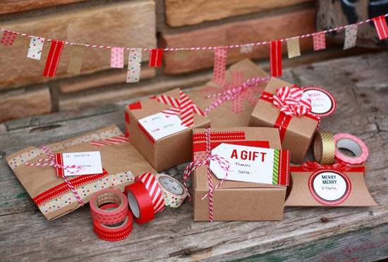 Presents in cardboard packaging with red ribbon accents wrapped around the group.