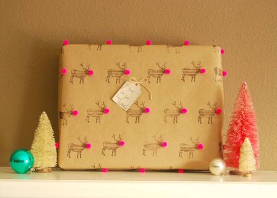 Gift box with reindeer with pom pom noses near bristle brush Christmas tree decorations.