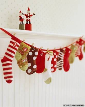 Colorful stockings are hanging on a line on a white wall.