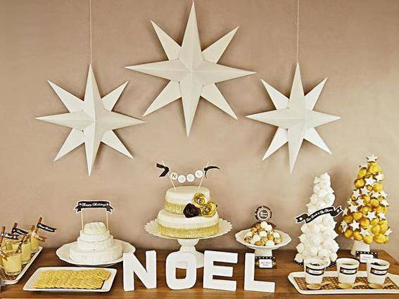 Three stars are hanging on the wall above a table decorated with food.