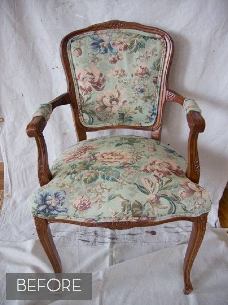 A wooden chair with a floral pattern sitting on a white tarp.