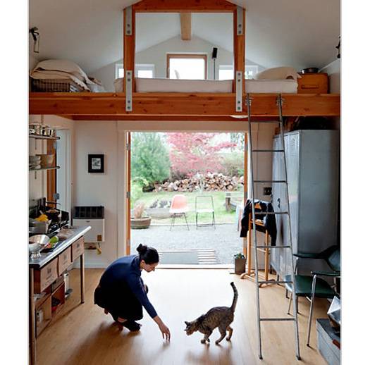 A woman is playing with a cat in the hall.