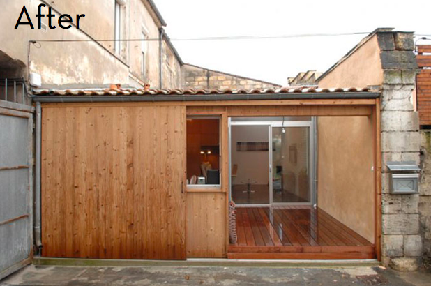 Sliding doors on a building made out of wood, stone, and tin.