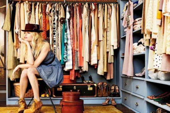 Woman sitting on a bench inside her walk-in closet.