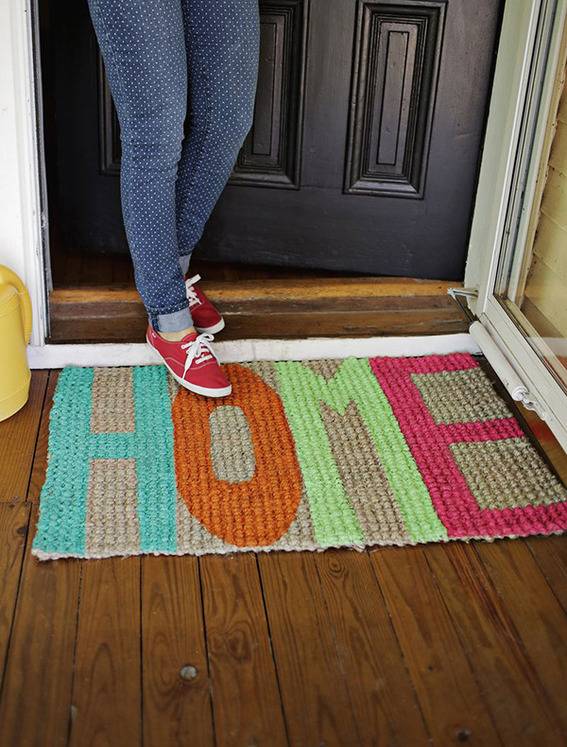 Woman with tennis shoes stepping out onto HOME welcome mat.