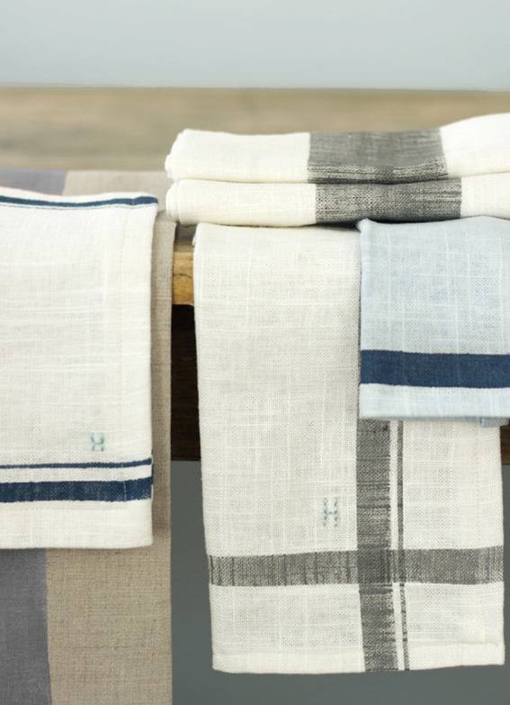 Different types of linen cloth with grey and blue dyes and an H imprinted into them.
