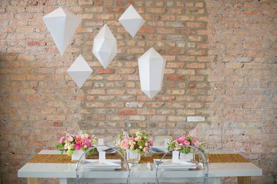 Table decoration with flower vases in a small space with paper hangings.