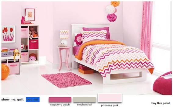 Pink color bedroom with cot, bedside table with lamp, floor mat, wall decor pom poms and storage cabinets.