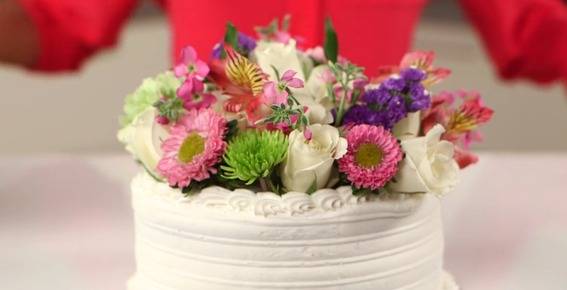 "White cake makeover with bunch of flowers."