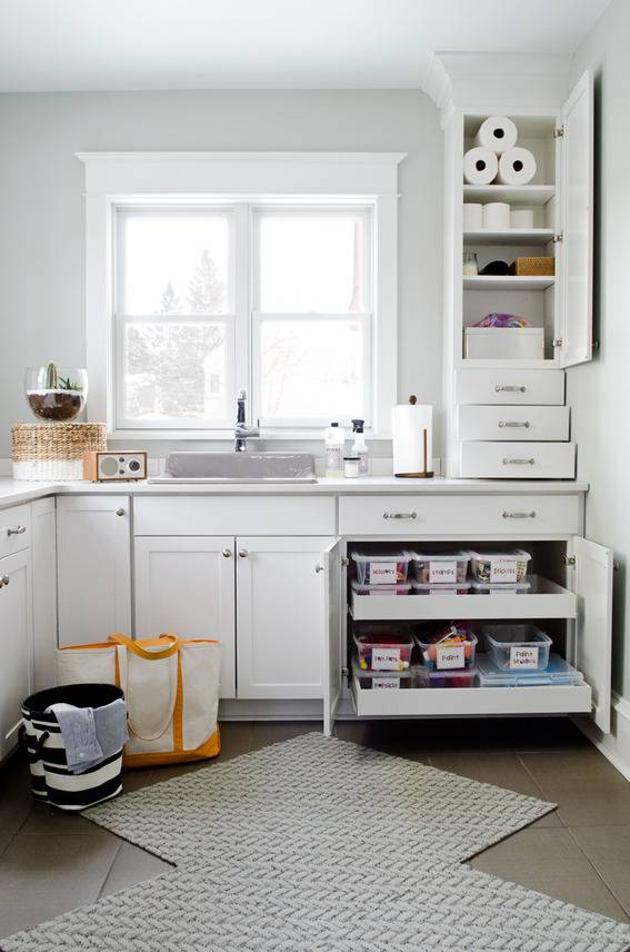 Laundry room with white shelves, and lots of organization.