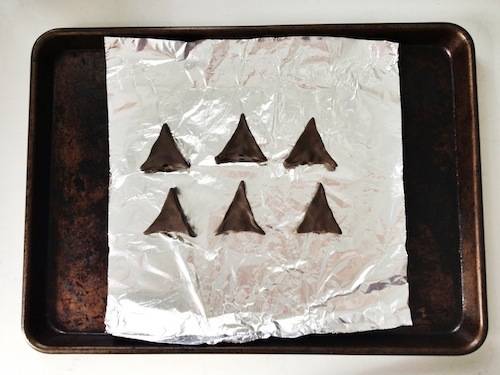 A container having silver paper and six triangle shape arrow heads.