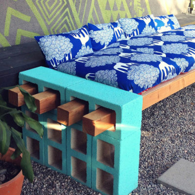 "Wooden bench with blue and white bed."